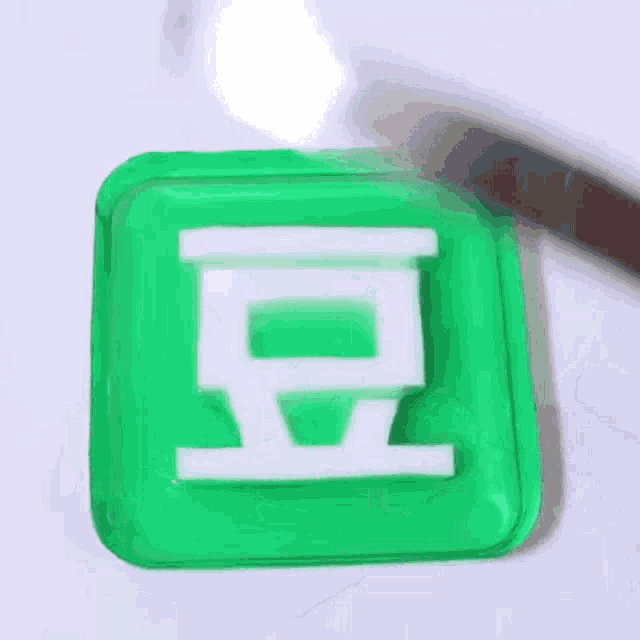 a green plastic container with the letter g on it and a knife in it