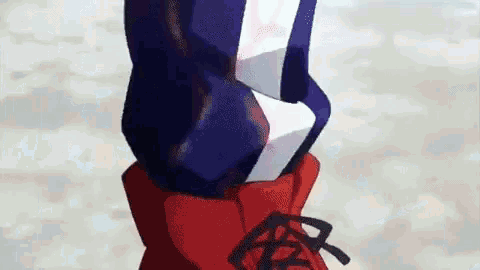 a close up of a person wearing a red , white and blue jacket and red boots .