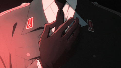 a man in a suit and tie has a red emblem on his sleeve
