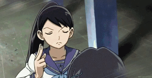a girl in a school uniform is holding her hair in a ponytail and making a funny face .