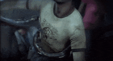 a man is being attacked by a snake in a video game while wearing a yellow shirt .