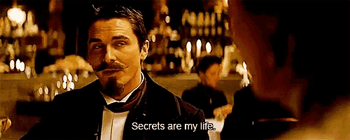 a man in a tuxedo is talking to another man and says secrets are my life