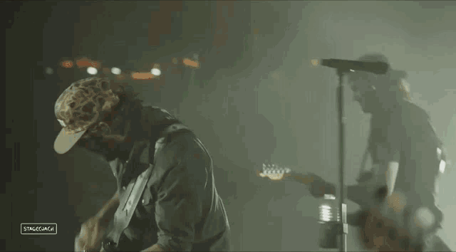a man playing a guitar in a dark room with stagecoach written on the bottom
