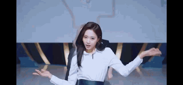a woman is dancing on a stage with her arms outstretched .