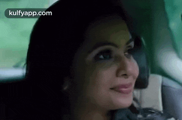 a woman is sitting in a car and smiling .