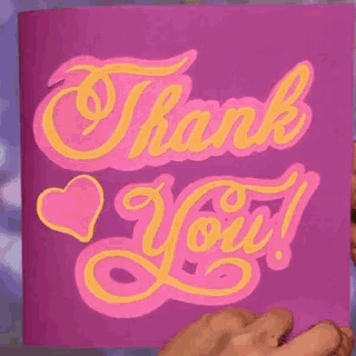 a person is holding a pink thank you card with yellow lettering