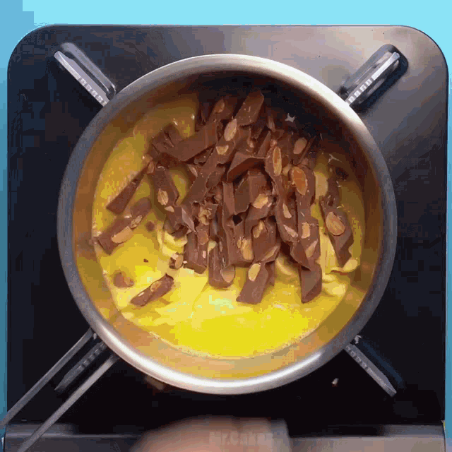 a pot of food is being cooked on a stove with a foreign language written on the bottom