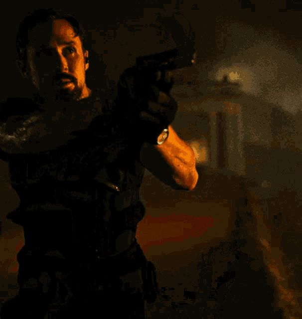 a man holding a gun in a dark room