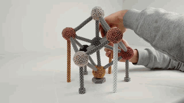 a person is playing with a toy made of magnets and balls