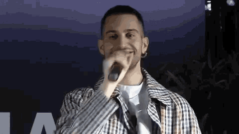a man is holding a microphone in his hand and singing into it .