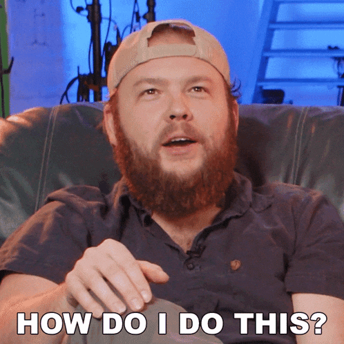 a man with a beard is sitting on a couch with the words how do i do this below him