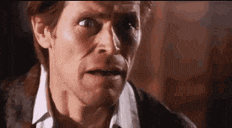 a close up of a man 's face with his mouth open and a surprised look on his face .