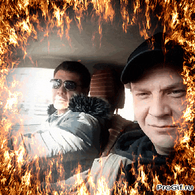 two men are sitting in a car with flames behind them
