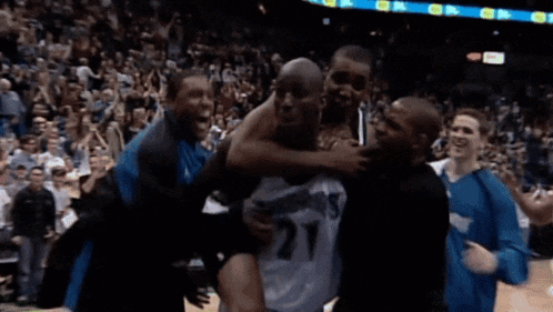 a man wearing a number 27 jersey is being lifted by a group of men