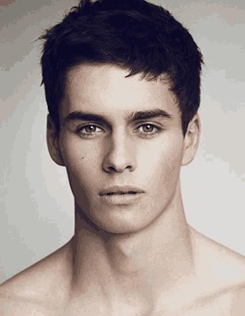 a close up of a young man 's face without a shirt .