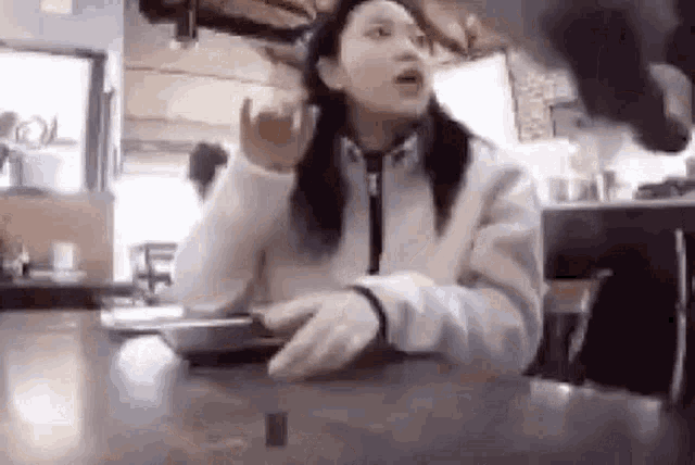a woman is sitting at a table talking to another woman .