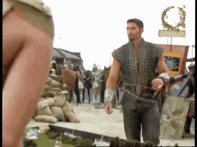 a man with a sword stands in front of a sign that says ' ae ' on it
