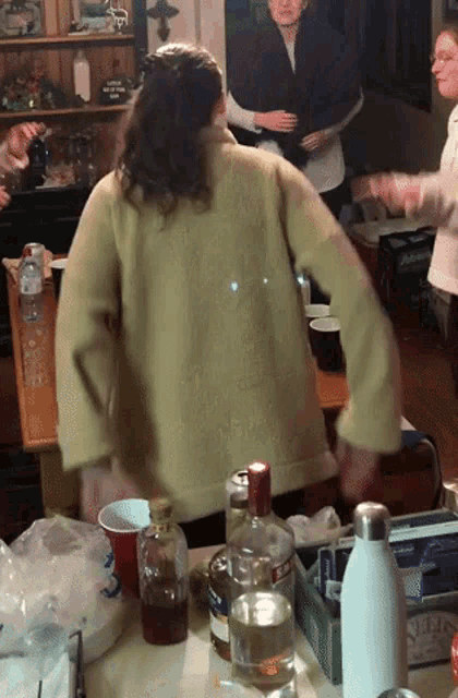 a bottle of smirnoff sits on a table next to a woman