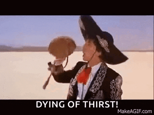 a man in a mariachi outfit is holding a fan in his hand .