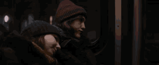 two women are sitting next to each other in a dark room