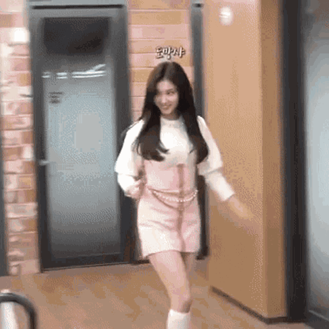 a woman in a pink dress is dancing in a room .