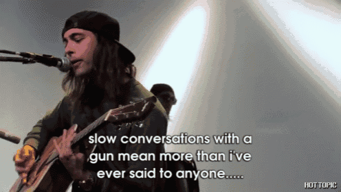 a man playing a guitar and singing into a microphone with the words slow conversations with a gun