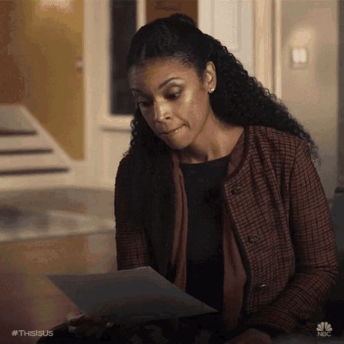 a woman holding a piece of paper with the hashtag #thisisus on it
