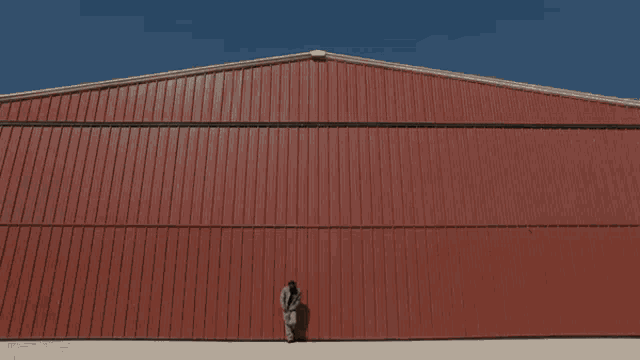 a man standing in front of a red building
