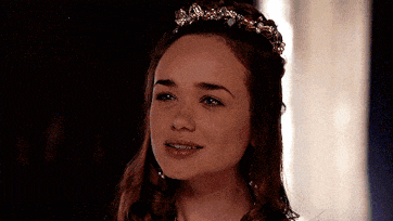 a woman wearing a tiara is smiling and looking at the camera