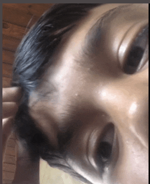 a close up of a person 's face with a hand on their head