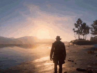 a man in a cowboy hat is walking on a beach