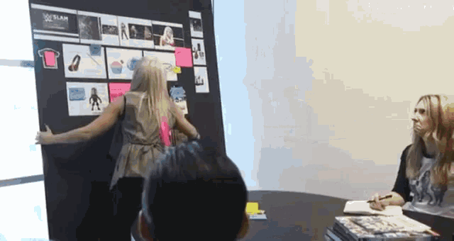 a woman stands in front of a board with pictures on it that says slam