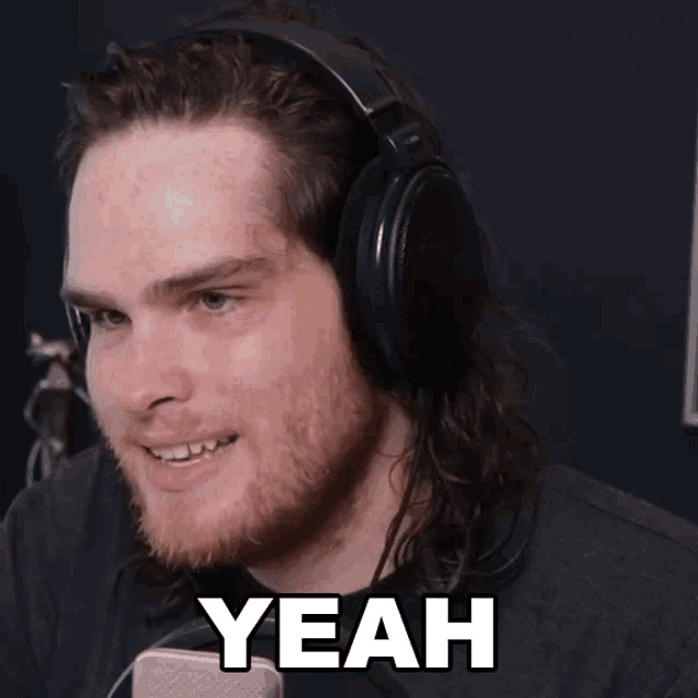 a man wearing headphones is smiling with the word yeah above him