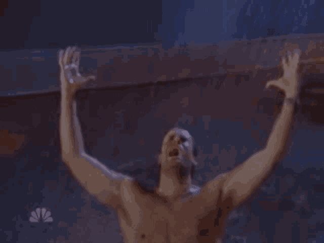 a shirtless man in a bathtub with his arms outstretched