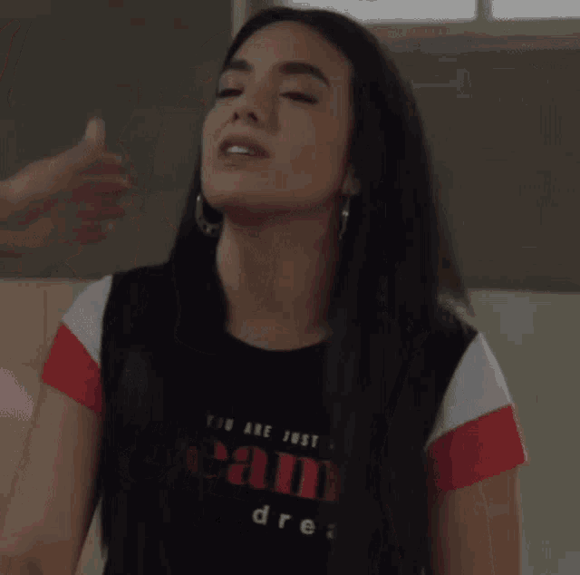 a woman wearing a t-shirt that says " you are just dream dre "