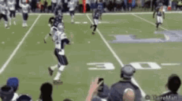 a football game is being played on a field with the number 30 on the sidelines .