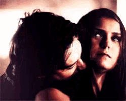 a man kisses a woman on the forehead in a dark room