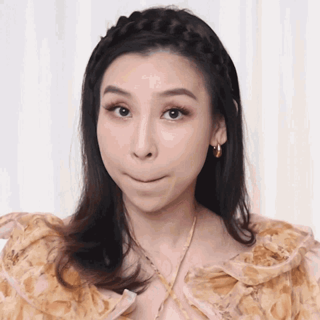a woman wearing a braided headband making a face