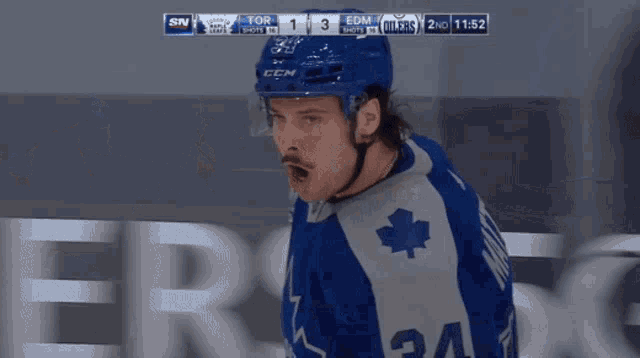 a hockey player wearing a blue jersey with the number 34 on it