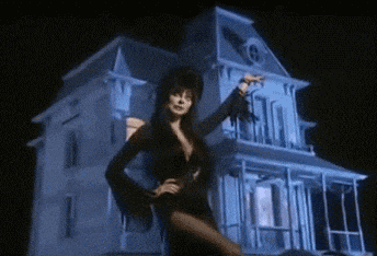 a woman stands in front of a haunted house at night
