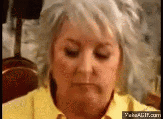 a woman in a yellow shirt is making a funny face .