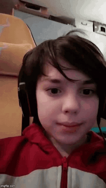 a young boy wearing headphones and a red and white jacket