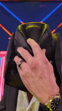 a man wearing a rolex watch covering his face