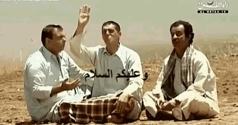 three men are sitting in the dirt with arabic writing on the bottom