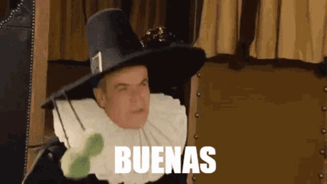 a man wearing a hat and a white collar is saying buenas