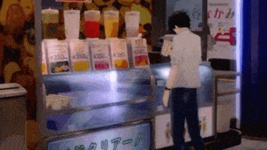 a man is standing in front of a display case filled with bottles of juice .