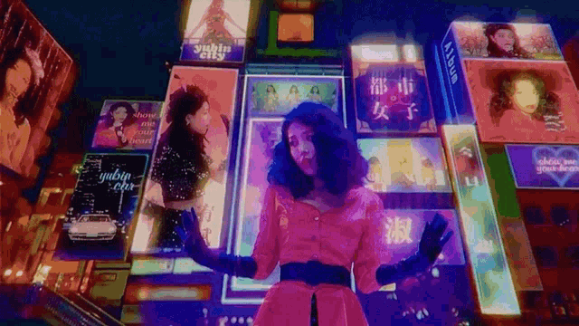 a woman in a pink dress is dancing in front of a sign that says yukiu city