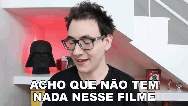 a man wearing glasses says " acho que nao tem nada nesse filme "