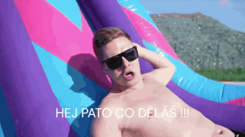 a shirtless man wearing sunglasses is laying on a purple and pink inflatable raft with the caption hej pato co delas !!!