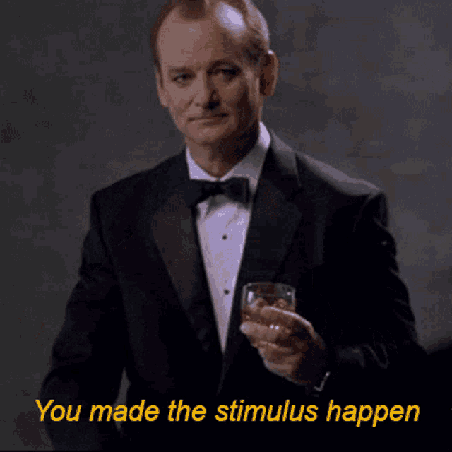 a man in a tuxedo holds a glass of whiskey with the words you made the stimulus happen below him